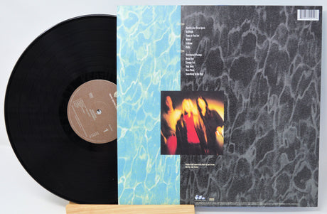 Vinyl record with cover featuring a band photo and text on a light gray background