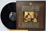 Vinyl record with its cover featuring a vintage-style image of a man playing guitar.