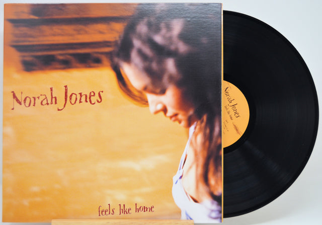 Norah Jones 'Feels Like Home' vinyl record with the album cover partially obscuring the black LP, photographed on a light neutral background.