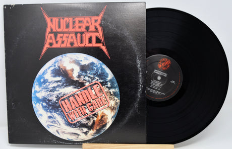 Vinyl record with 'Nuclear Assault' album cover featuring a globe and red text.