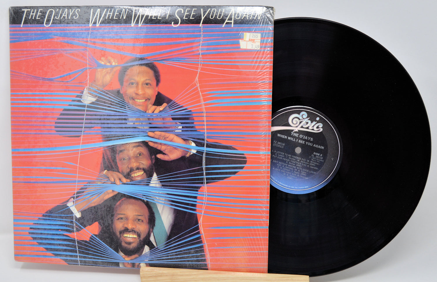Vinyl record with cover featuring a band on a red background