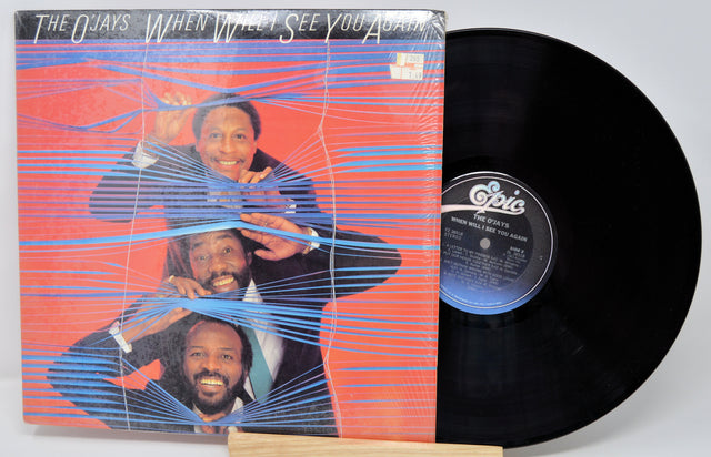 Vinyl record with cover featuring a band on a red background