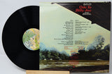 Vinyl record with a landscape cover featuring trees and water.