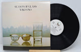 A vinyl record of 'Season of Glass' by Yoko Ono with the album cover visible. The cover features a photograph of a glass of water and a cityscape.