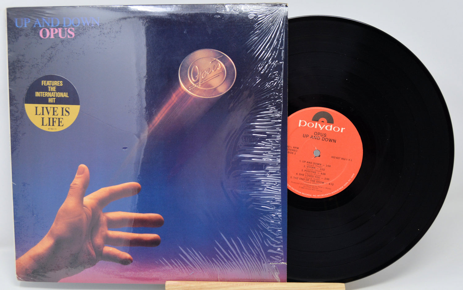 Vinyl record with cover featuring a hand and 'Opus' text on a white background