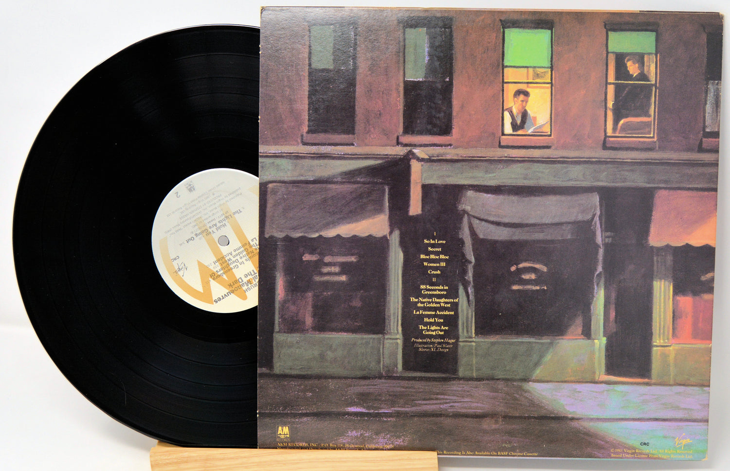 Vinyl record with a colorful album cover featuring a building facade.