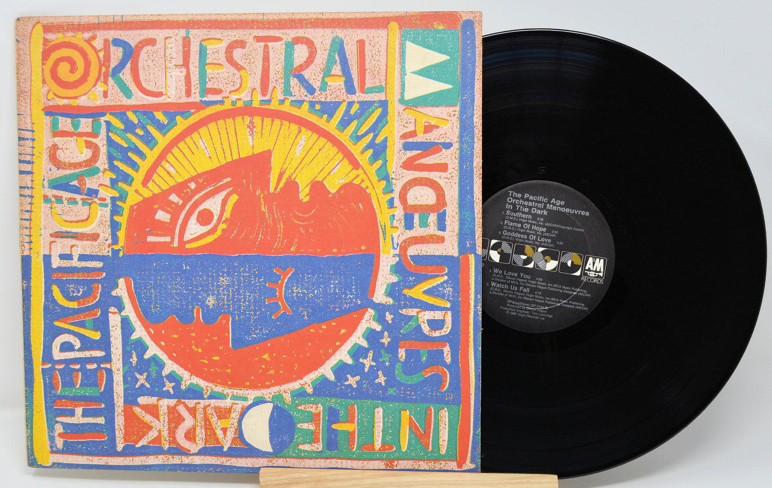 Vinyl record with colorful cover featuring text and abstract designs