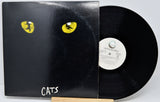 A black vinyl record partially pulled from its sleeve, featuring a black cover with two yellow cat eyes and the word 'CATS' in white near the bottom. The center label reads 'Ceffen Records' and 'Cats'.