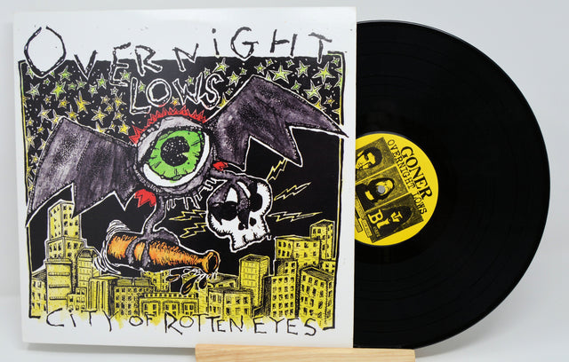 Front cover of Overnight Lows City of Rotten Eyes vinyl with illustrated monster, cityscape, and album title