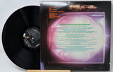 Vinyl record with cover featuring text and a face, on a light gray background