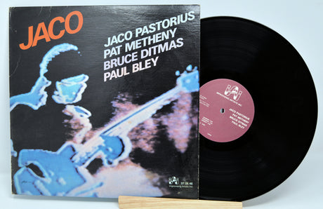 Vinyl record with cover featuring Jaco Pastorius, Pat Metheny, Bruce Ditmas, and Paul Bley on a light blue background.