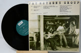 Vinyl record with cover featuring a band playing music in a room.