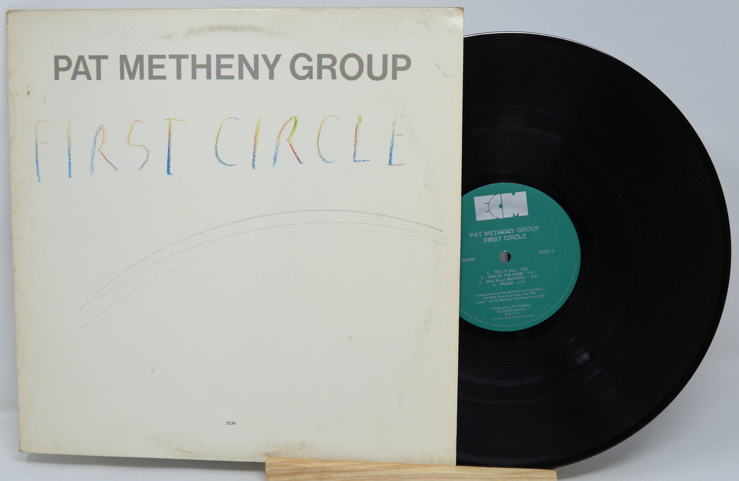 Vinyl record and cover of 'First Circle' by Pat Metheny Group on a white background