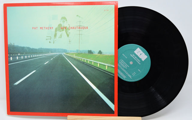 Vinyl record with cover featuring a road scene and album details.
