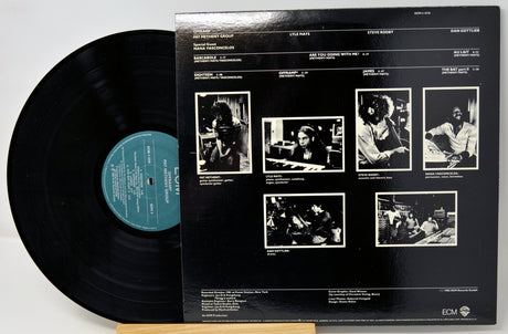 Vinyl record with a black cover featuring black and white photos and text.