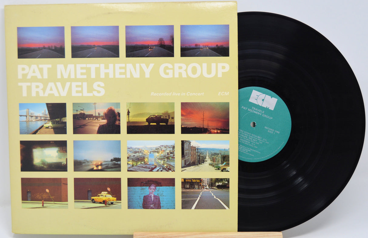 Vinyl record with cover featuring images and 'Pat Metheny Group Travels' text on a white background