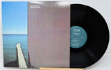 Vinyl record with cover showing a coastal scene and ECM label