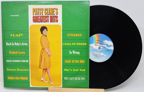 Patsy Cline's Greatest Hits vinyl record album with the green and yellow cover jacket and a black vinyl record partially pulled out, displayed on a wooden stand.