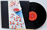 Vinyl record with a colorful cover featuring bowls of red and blue substances.