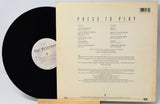 Vinyl record with cover displaying tracklist on a light gray background