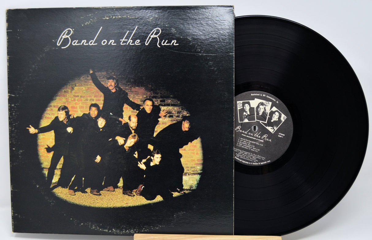 Vinyl record and cover titled 'Band on the Run' with a group of people in front of a brick wall.