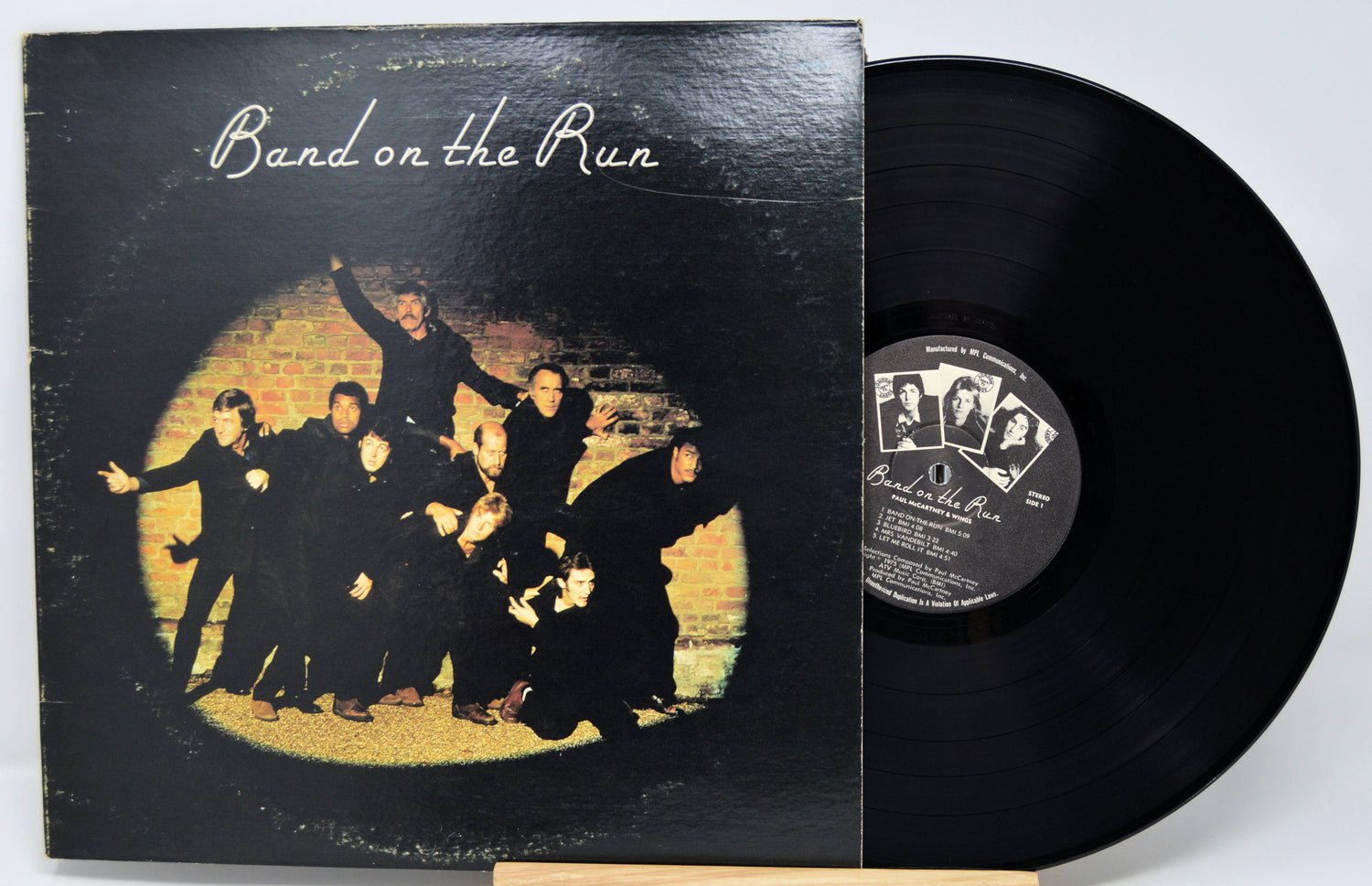 Vinyl record and cover titled 'Band on the Run' with a group of people in front of a brick wall.