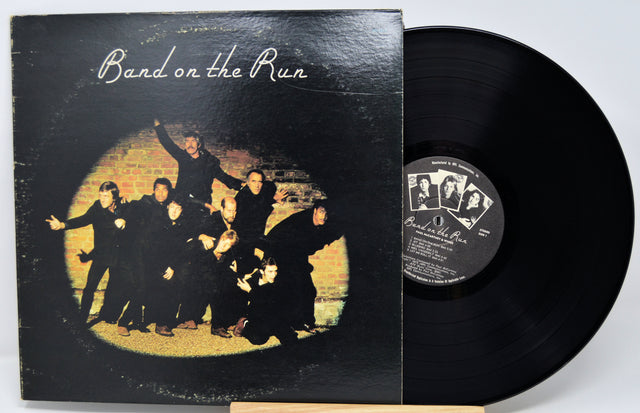 Vinyl record and cover titled 'Band on the Run' with a group of people in front of a brick wall.