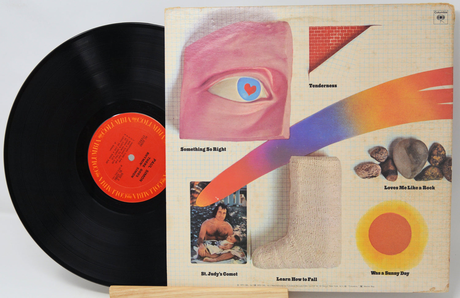Vinyl record with colorful album cover featuring abstract designs and text.