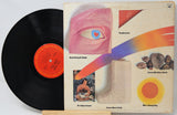 Vinyl record with colorful album cover featuring abstract designs and text.