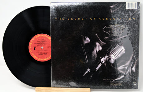 Vinyl record with a cover featuring a leather jacket and a microphone, titled 'The Secret of Association'.