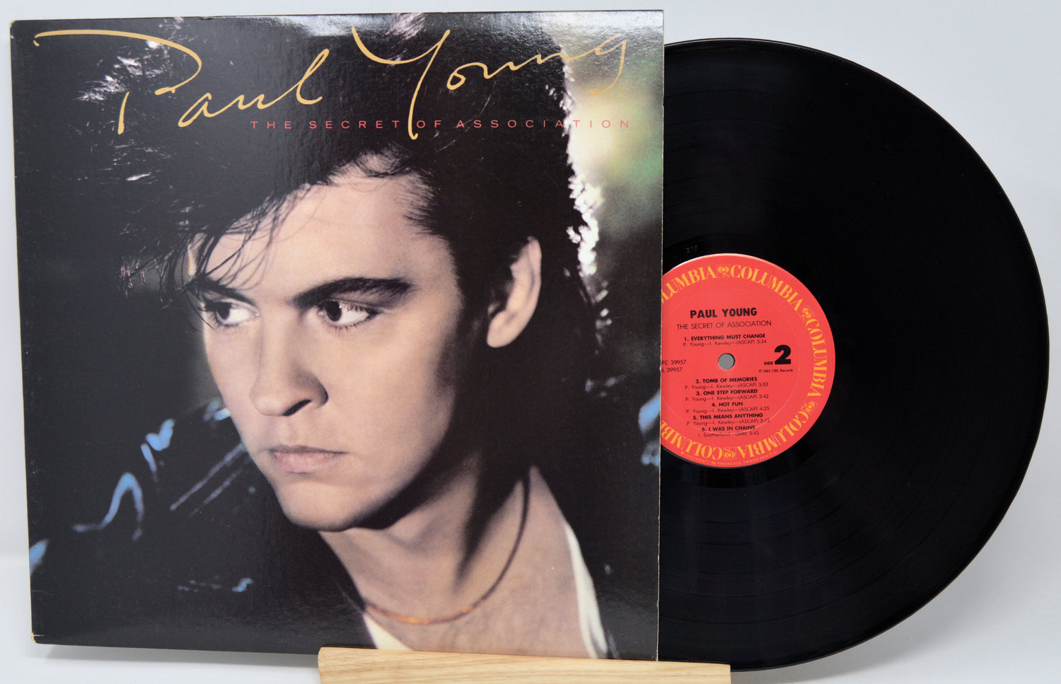 Vinyl record with cover featuring a portrait and album title 'The Secret of Abandonment' by Paul Young.