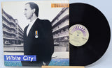 Vinyl record with cover featuring a person in a suit and 'White City' text, on a light blue background.