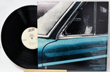 Vinyl record with a car-themed cover on a white background
