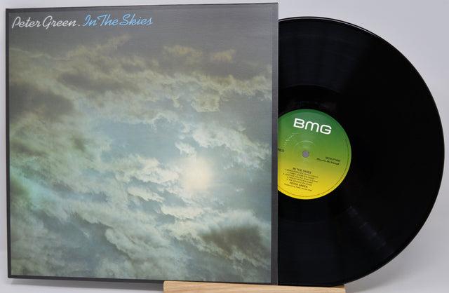 Peter Green - In The Skies vinyl record LP with the album cover standing next to the black vinyl disc on a small wooden easel against a light gray background.