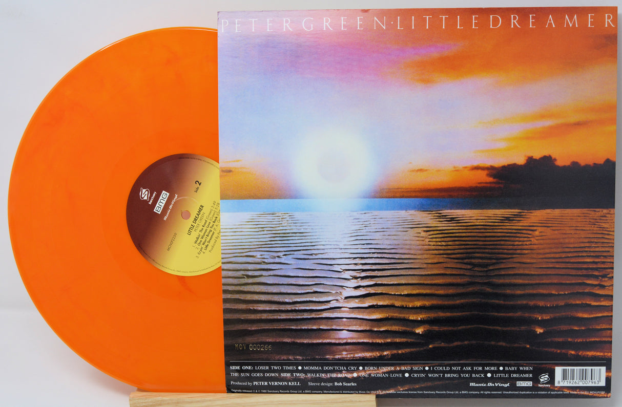 Peter Green's 'Little Dreamer' vinyl record LP shown with its illustrated cover sleeve. The record is a translucent orange color, and the sleeve features a sunset over rippling water with the album title at the top.