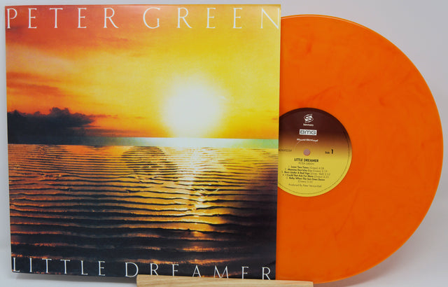 Peter Green's 'Little Dreamer' vinyl record with its album cover sleeve and a translucent orange record partially visible behind it.