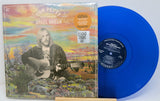 Blue vinyl record with a colorful album cover featuring a person playing guitar.