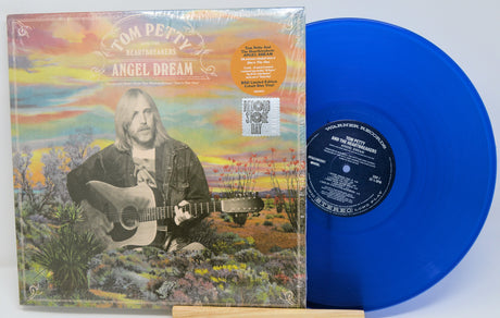 Blue vinyl record with a colorful album cover featuring a person playing guitar.