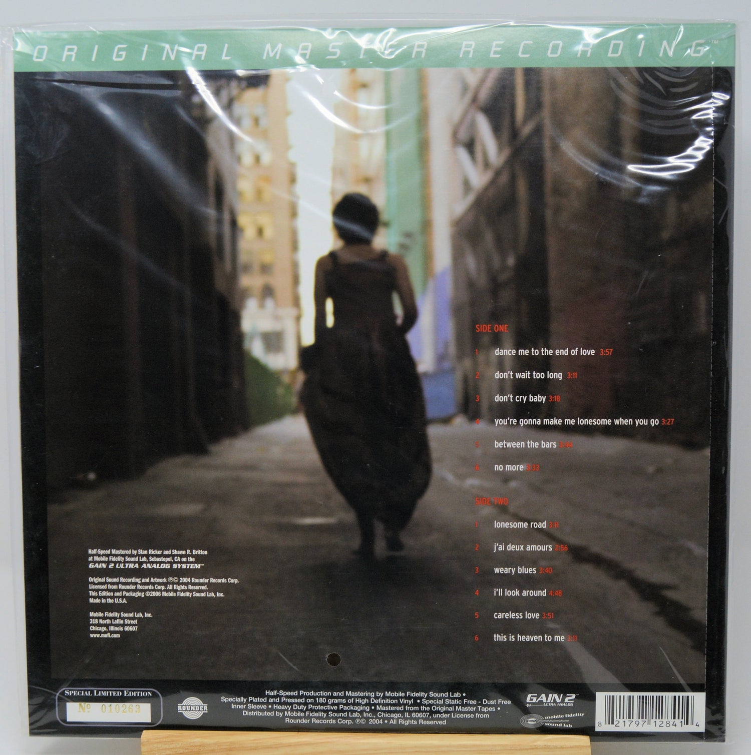 Back cover of a vinyl record sleeve for Sam's Club Original Master Recordings, featuring a dark street scene with a person walking away, tracklist text on the right, and a barcode at the bottom.