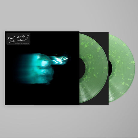 Vinyl record with green marbled design and black cover on a gray background