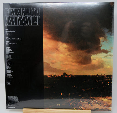 Pink Floyd Animals vinyl record album cover, showing the printed tracklist on the left and the dramatic stormy sky cityscape artwork on the right, photographed standing upright against a light background.
