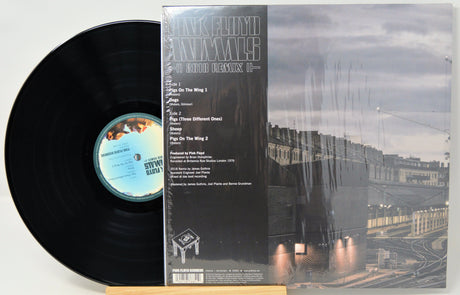 Pink Floyd Animals - Both Sides 2 vinyl record shown with the black LP partially pulled from the back cover, which features a cityscape photograph and track listing, photographed on a light background.