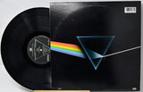 Vinyl record with cover featuring a rainbow and triangle design on a black background