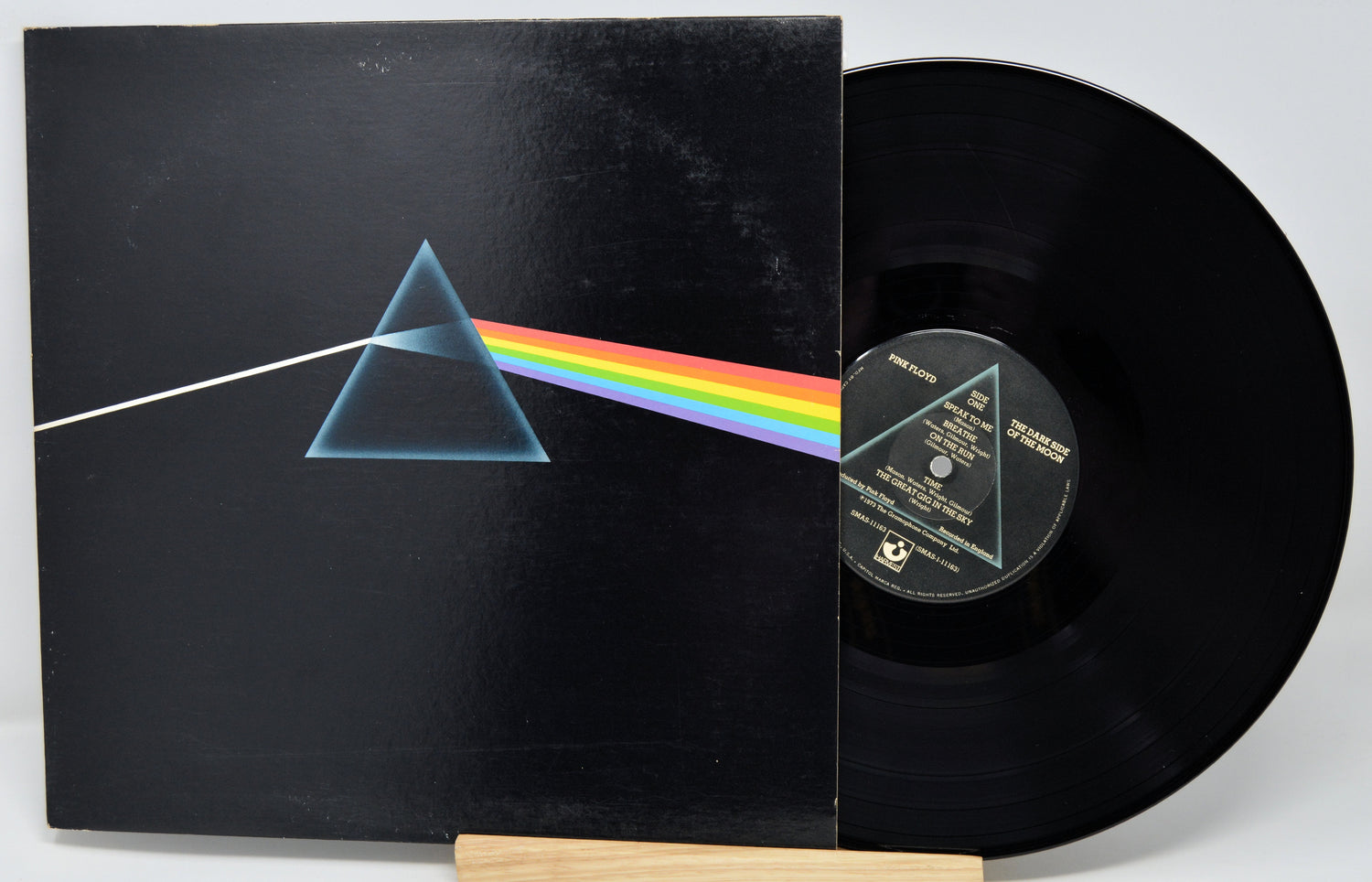 Vinyl record with 'The Dark Side of the Moon' album cover featuring a triangle and rainbow.