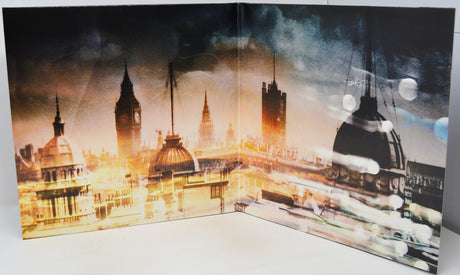 A square art print or canvas featuring a stylized London cityscape with Big Ben, St. Paul's Cathedral, and other landmarks, rendered in dramatic golden-hour lighting with motion-blur effects.