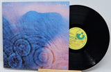 Vinyl record with a colorful cover and a visible label on a light gray background