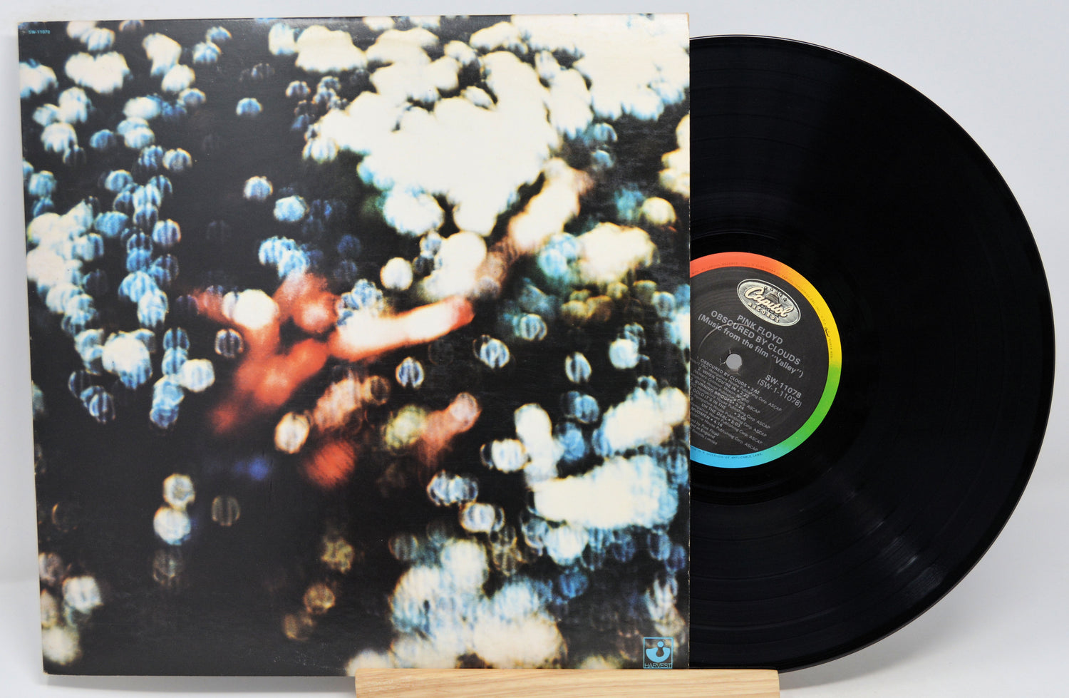 Vinyl record with a colorful cover featuring abstract designs on a white background