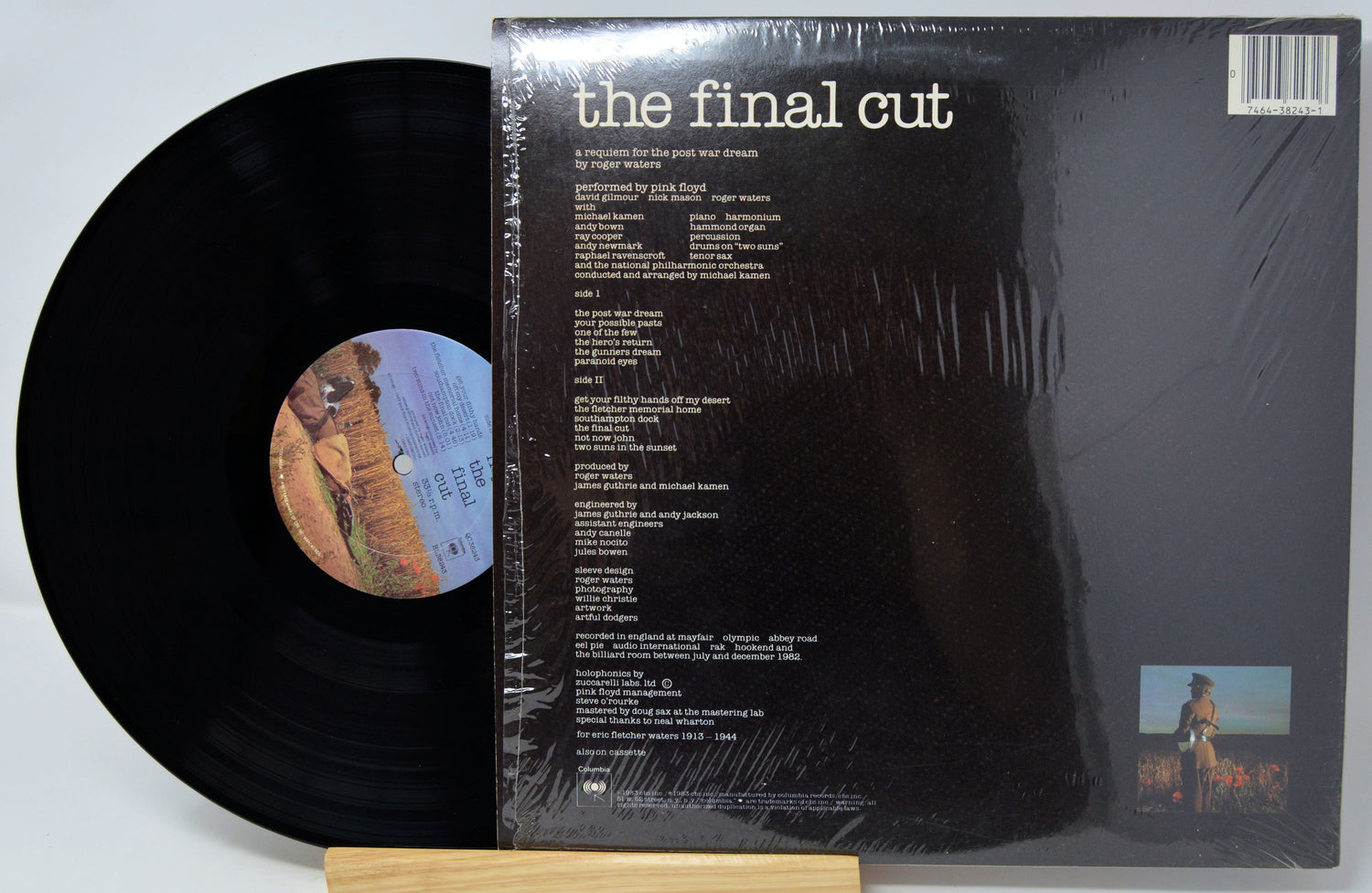 Vinyl record with cover displaying text and images on a light gray background