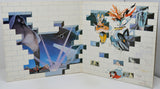 An open art book or album spread, showing two illustrated pages with collage-style fantasy artwork, including a large shark-like figure on the left and multiple anime-inspired characters on the right, photographed against a plain light background.