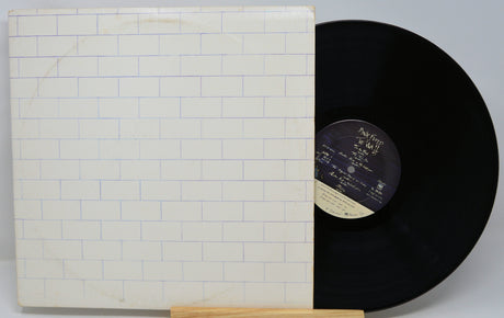 Vinyl record with a white cover featuring a brick pattern on a gray background